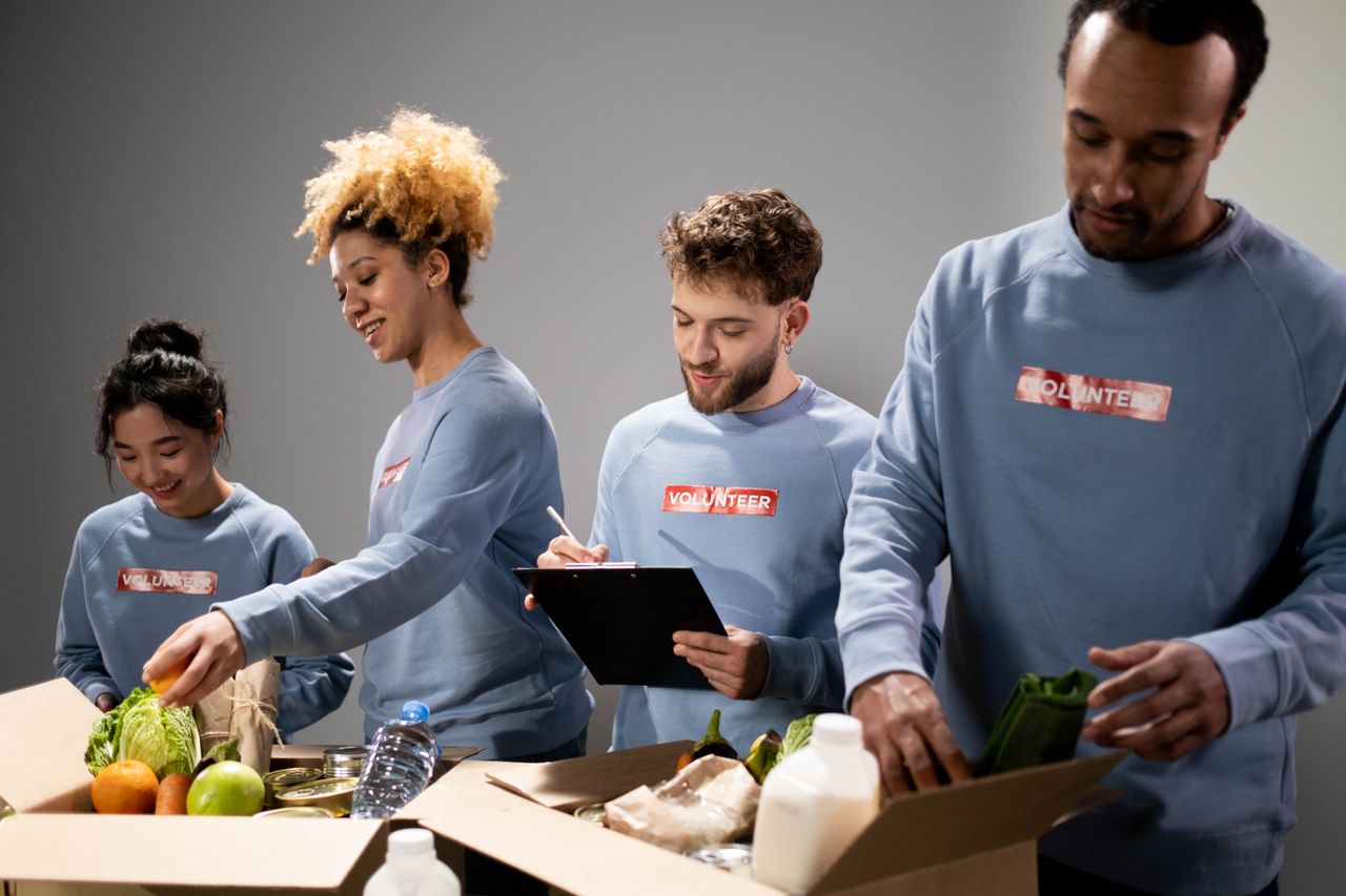 contact-img Four diverse volunteers pack food donations with teamwork and dedication.